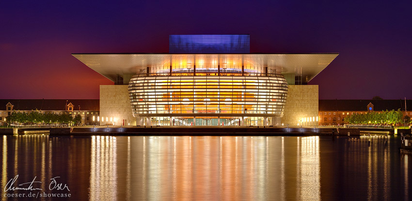 Das Opernhaus spiegelt sich in der Abenddämmerung im Wasser in Kopenhagen, Dänemark.