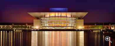 Das Opernhaus spiegelt sich in der Abendd&auml;mmerung im Wasser in Kopenhagen, D&auml;nemark.