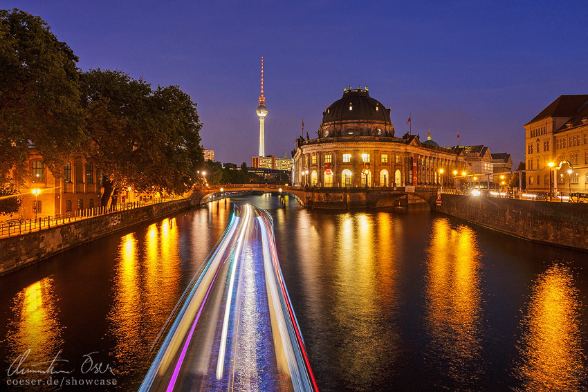 Ein auf der Spree fahrendes Schiff, das Bodemuseum und der Fernsehturm in Berlin, Deutschland.