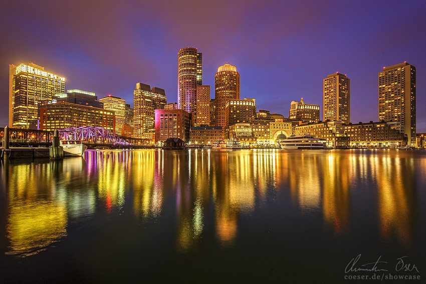 Beleuchtete Skyline von Boston Downtown während eines Sonnenuntergangs in Boston, USA.