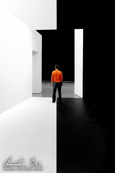 Mann steht zwischen schwarzer und weißer Wand im Kunsthaus Graz, Österreich.