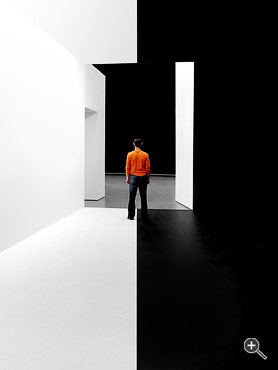 Mann steht zwischen schwarzer und wei&szlig;er Wand im Kunsthaus Graz, &Ouml;sterreich.