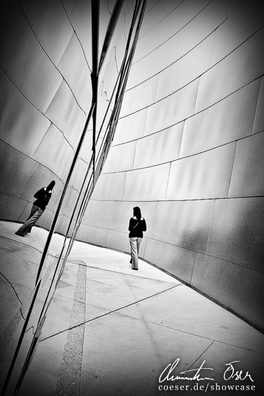 Frau spiegelt sich in der Fassade der Walt Disney Konzerthalle in Los Angeles, USA.