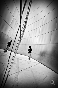 Frau spiegelt sich in der Fassade der Walt Disney Konzerthalle in Los Angeles, USA.