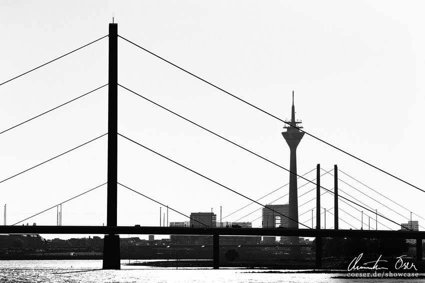 Die Silhouette der Oberkasseler Brücke und des Rheinturms in Düsseldorf, Deutschland.