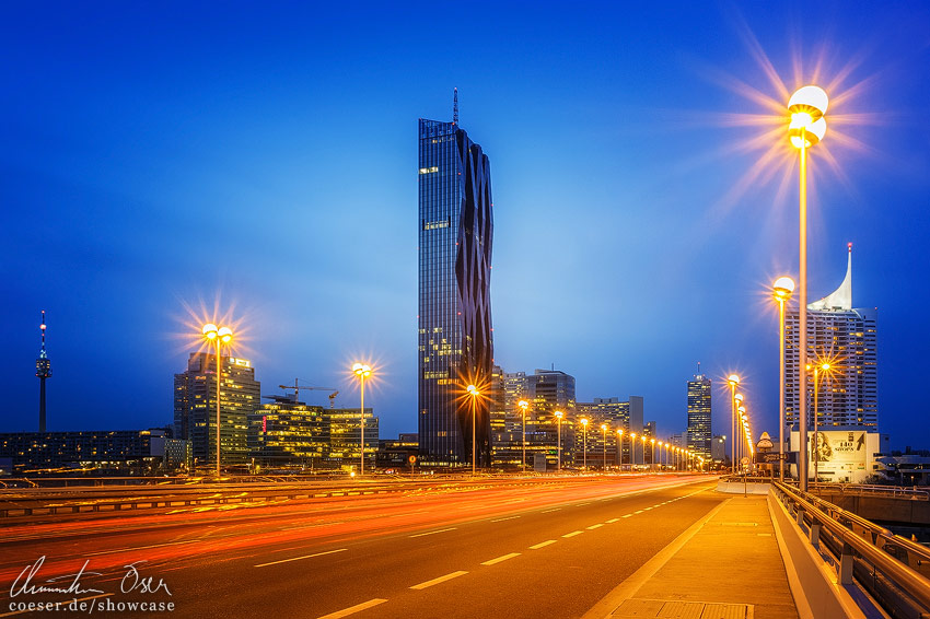 Beleuchtete Reichsbrücke, Donaucity und DC Tower in Wien, Österreich.