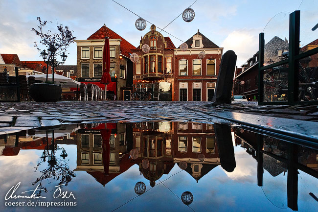 Nach einem Regenschauer bilden sich noch mehr Reflektionen in der Altstadt von Alkmaar, Niederlande.