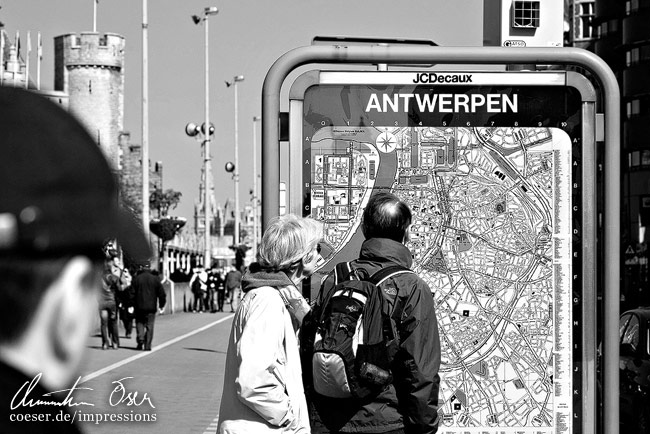 Touristen orientieren sich mit Hilfe eines Stadtplans in Antwerpen, Belgien.