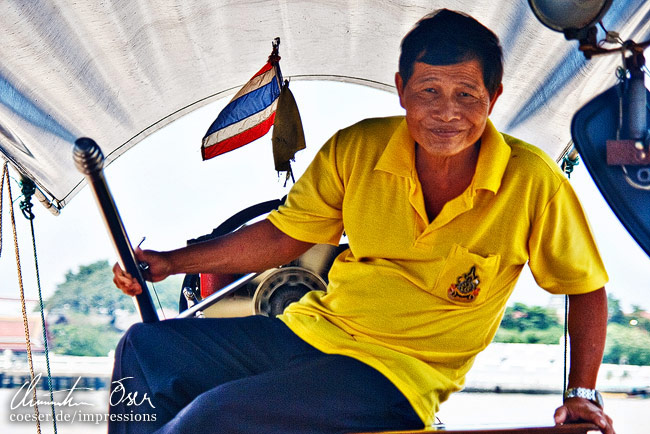 Ein Einheimischer steuert ein Long-Tail-Boot in Bangkok, Thailand.