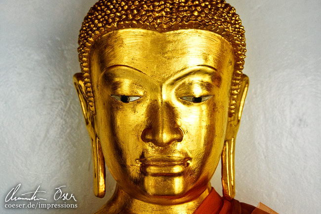 Eine goldene Buddha-Statue im Großen Palast in Bangkok, Thailand.