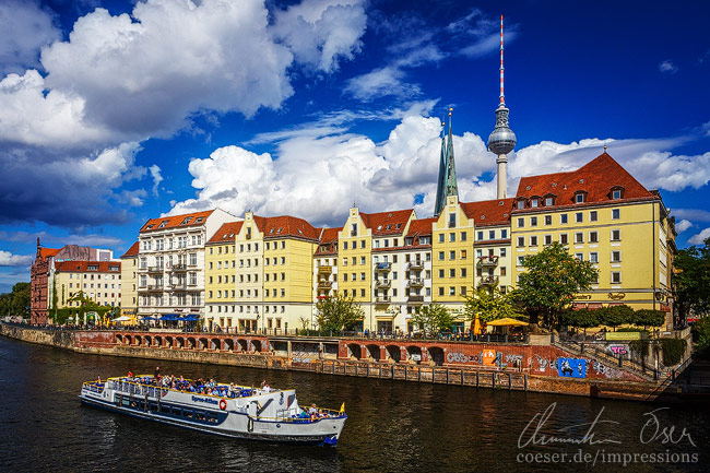 Ein Schiff auf der Spree vor dem Nikolaiviertel und dem Berliner Fernsehturm in Berlin, Deutschland.