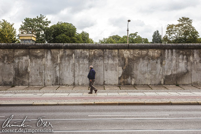 Ein Mann geht entlang der historischen Berliner Mauer auf der Bernauer Strasse in Berlin, Deutschland.
