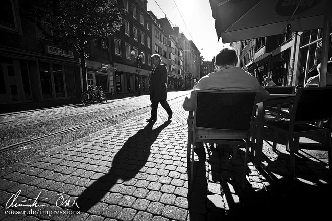 Schatten eines Fußgängers in der Altstadt in Düsseldorf, Deutschland.