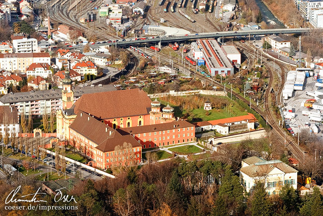 Blick auf das Stift Wilten und Teile des Hauptbahnhofs, gesehen von der Bergisel-Aussichtsplattform in Innsbruck, Österreich.