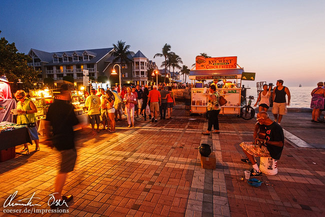 Menschen gehen an Straßenkünstlern am Sunset Pier vorbei in Key West, USA.