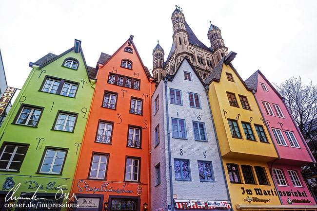 Bunte Häuser am Fischmarkt in der Altstadt und die Groß-St.-Martin-Kirche in Köln, Deutschland.