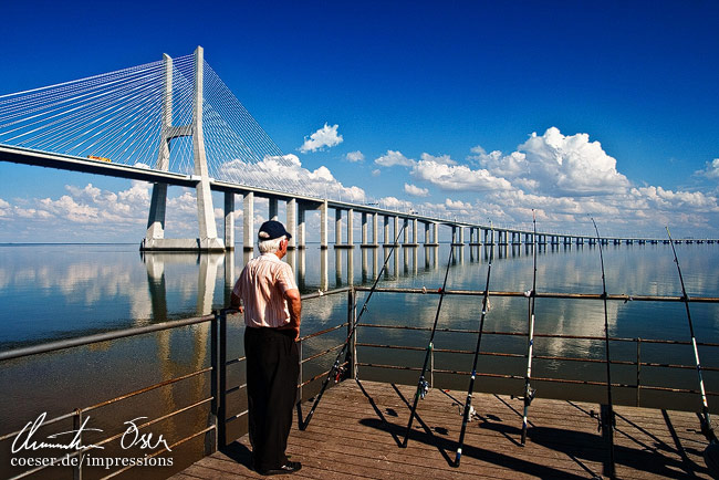 Einer von zahlreichen Fischern vor der Vasco-da-Gama-Brücke in Lissabon, Portugal.