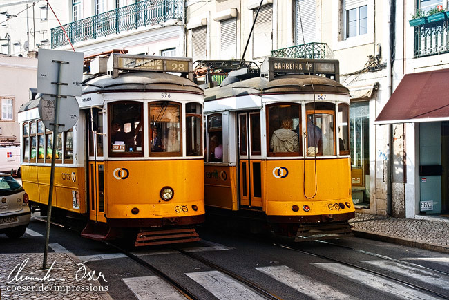 Zwei Züge der berühmten Straßenbahnlinie 28 begegnen sich in Lissabon, Portugal.