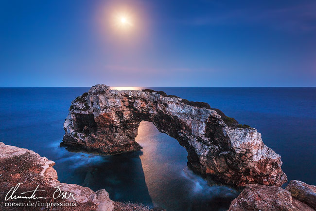 Mondlicht beleuchtet das Es-Pontas-Felsentor in Cala Santanyi auf der Insel Mallorca, Spanien.