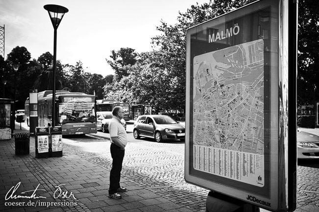 Ein Mann steht neben einem großen Stadtplan von Malmö, Schweden.