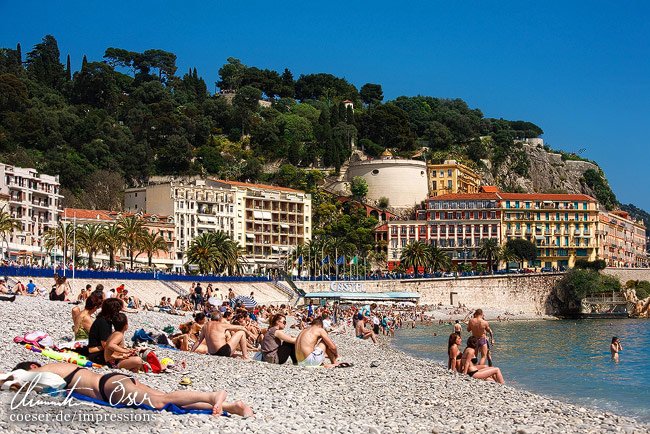 Ein Steinstrand an der Quai des Etats-Unis Promenade in Nizza, Frankreich.