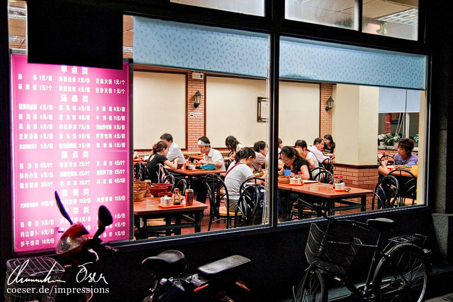 Menschen essen in einer lokalen Garküche in Peking, China.