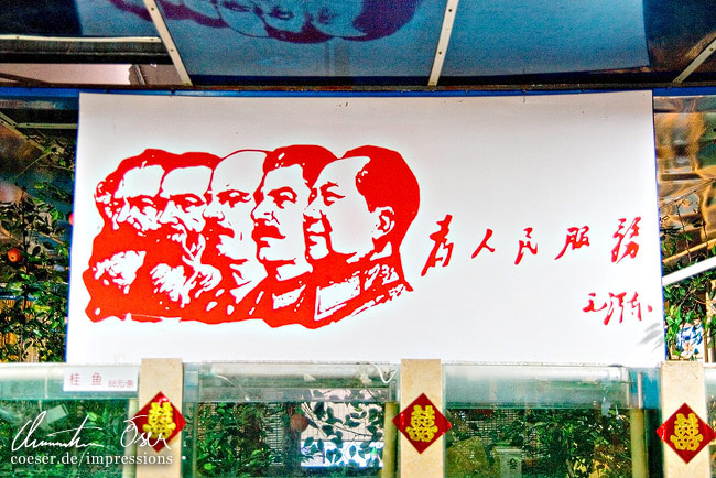 Ein Schild bildet große Diktatoren ab in Peking, China.