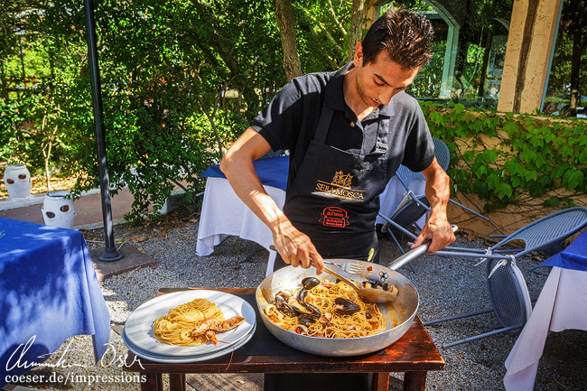 Ein einheimischer Koch bereitet Spaghetti Frutti di Mare zu auf der Insel Sardinien, Italien.