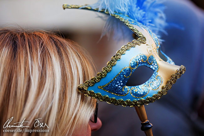 Eine Frau hält sich eine Maske vor das Gesicht in Venedig, Italien.